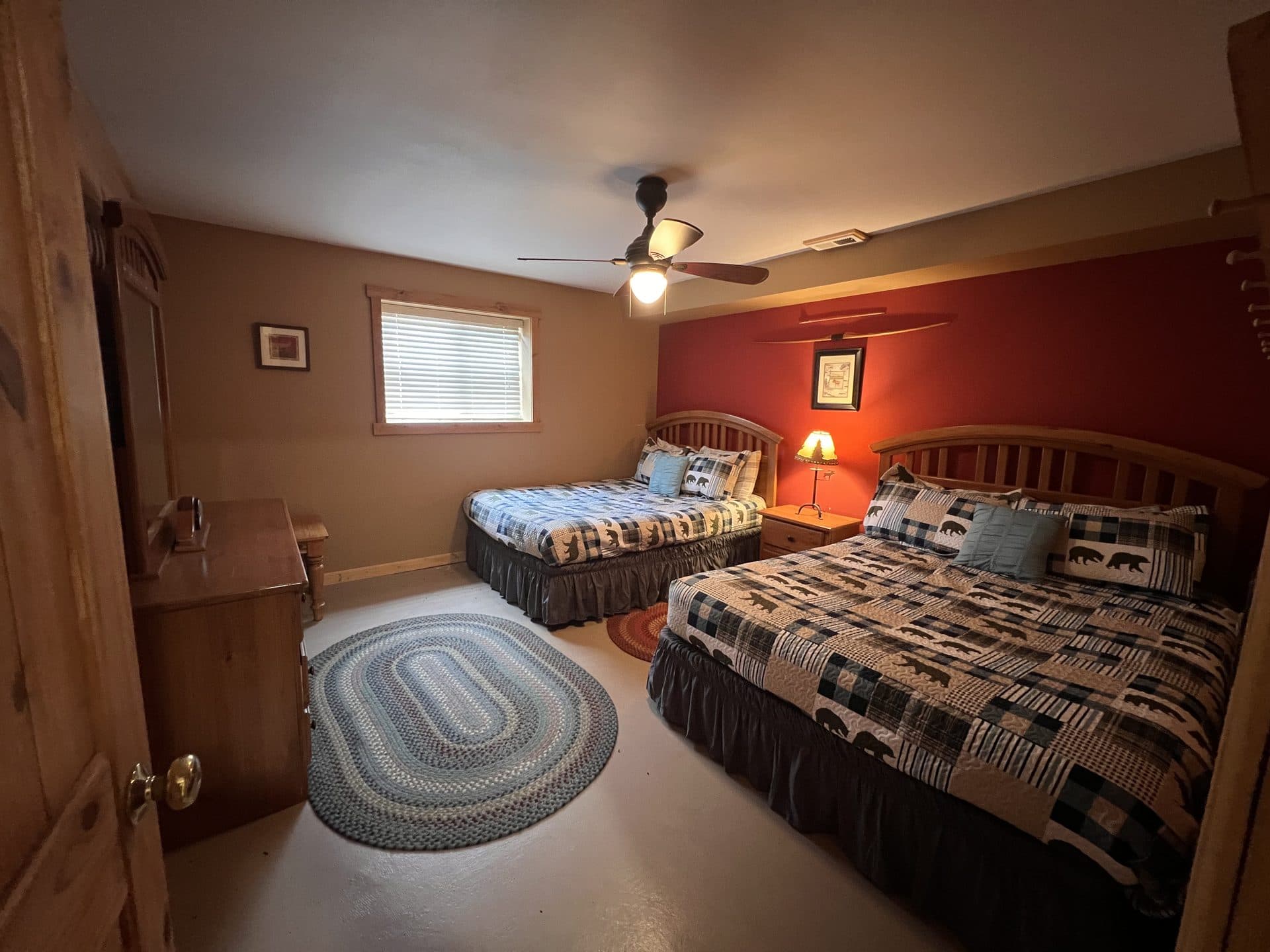Cabin bedroom with a made bed and warm wood walls at Alpine Lakes Lodge
