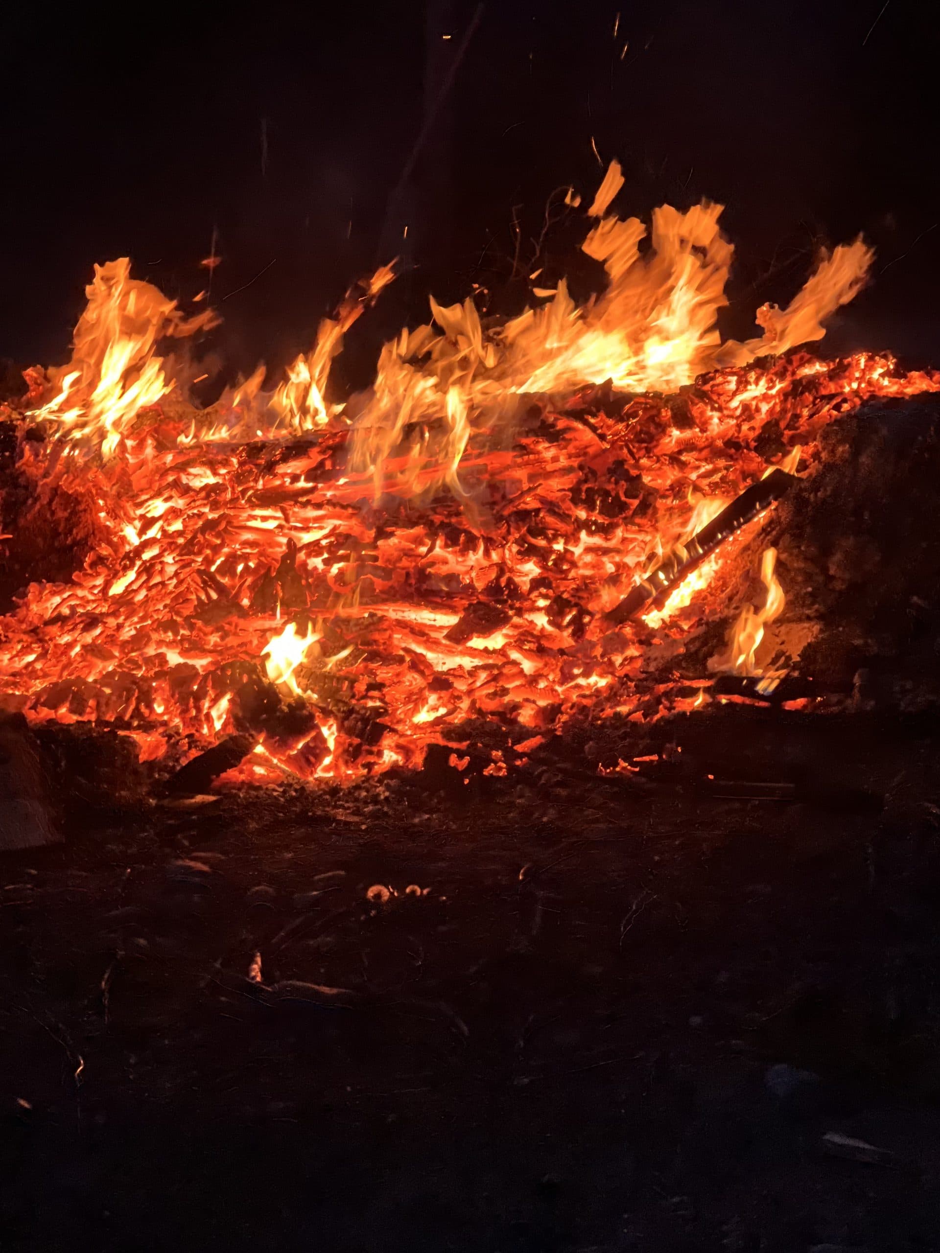 Campfire burning after dark at a campsite on the 54-acre Alpine Lakes Lodge property in Easton, Washington