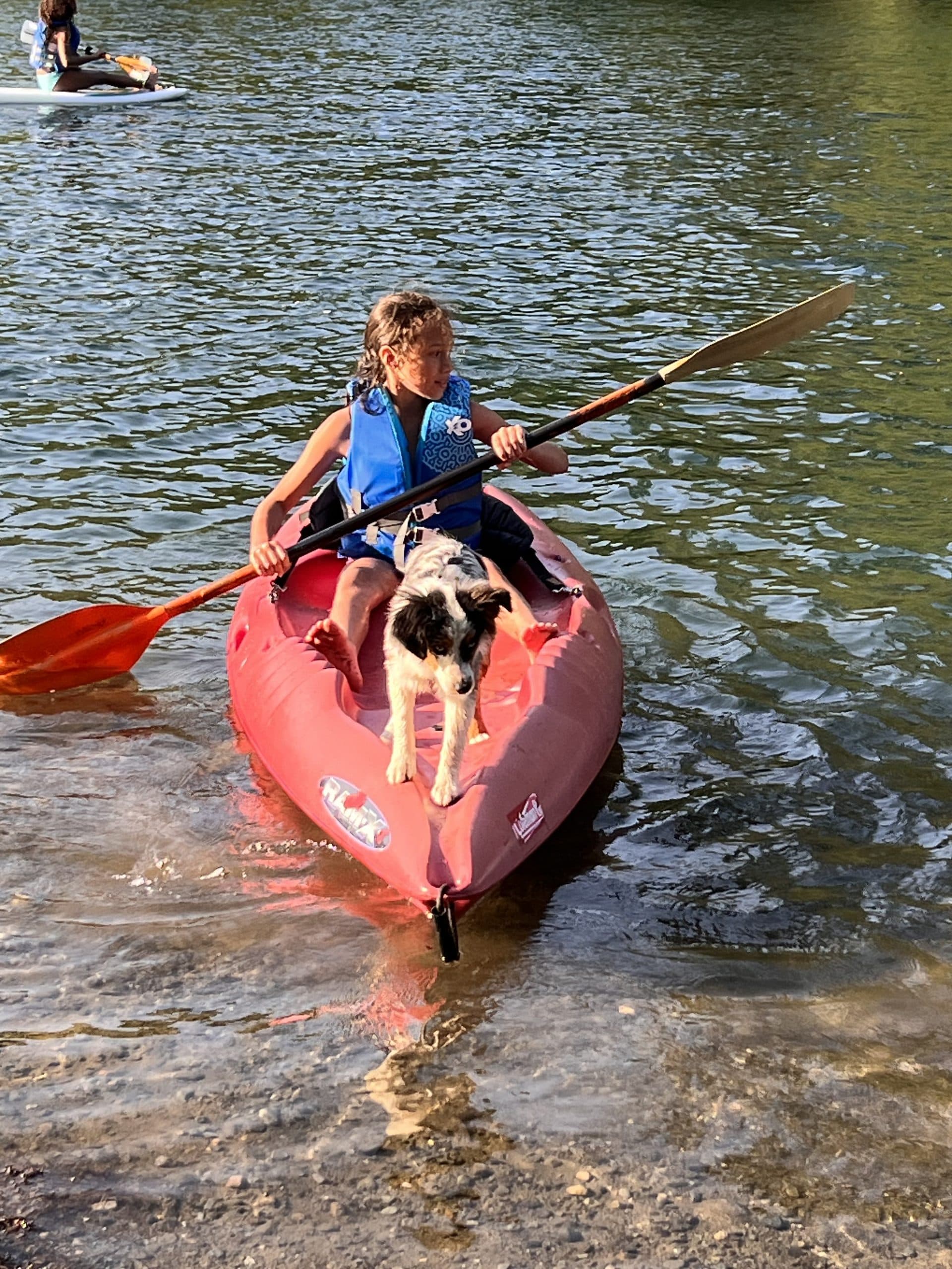 A child and a dog kayaking together on one of the private lakes at Alpine Lakes Lodge in Easton, Washington