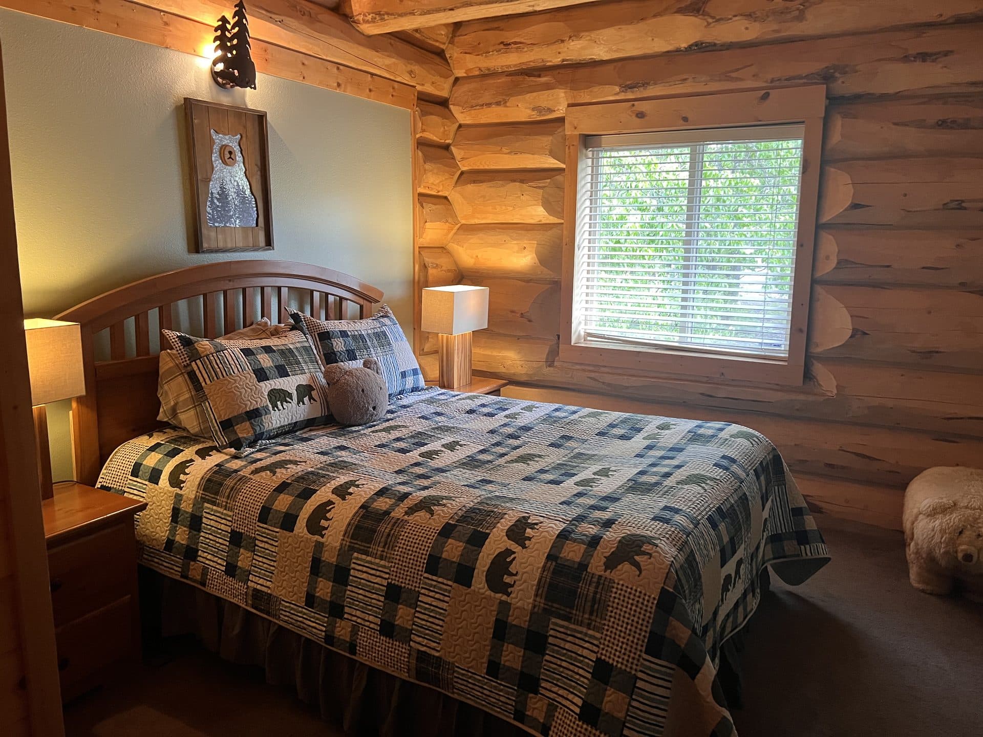 Cozy lodge bedroom with log walls and wilderness quilt
