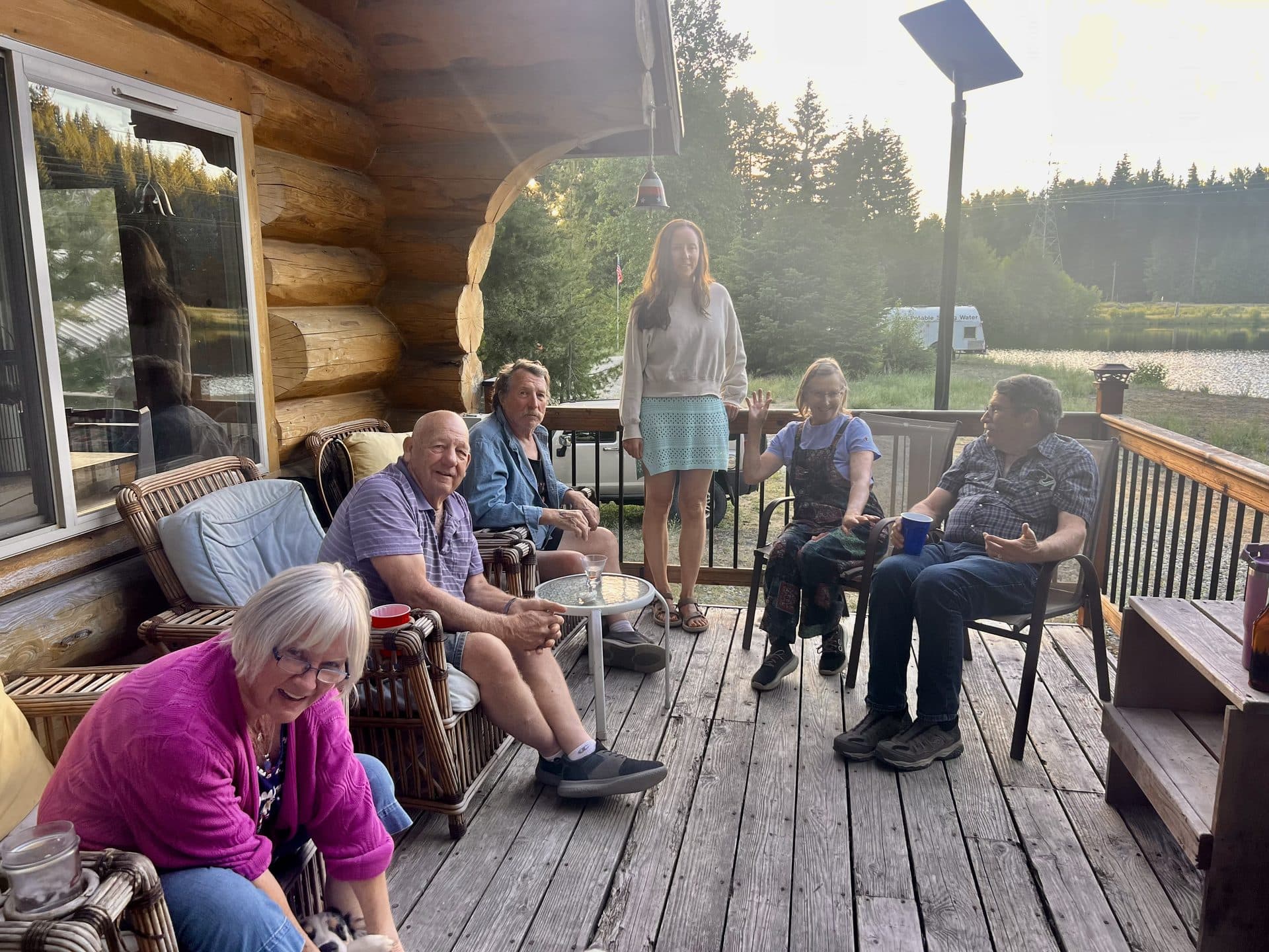 Family gathering on the lodge deck at sunset overlooking the property