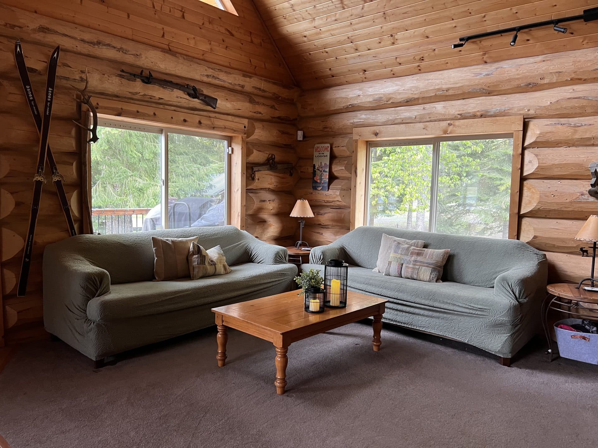 Log lodge living room with vaulted ceilings and wood fireplace