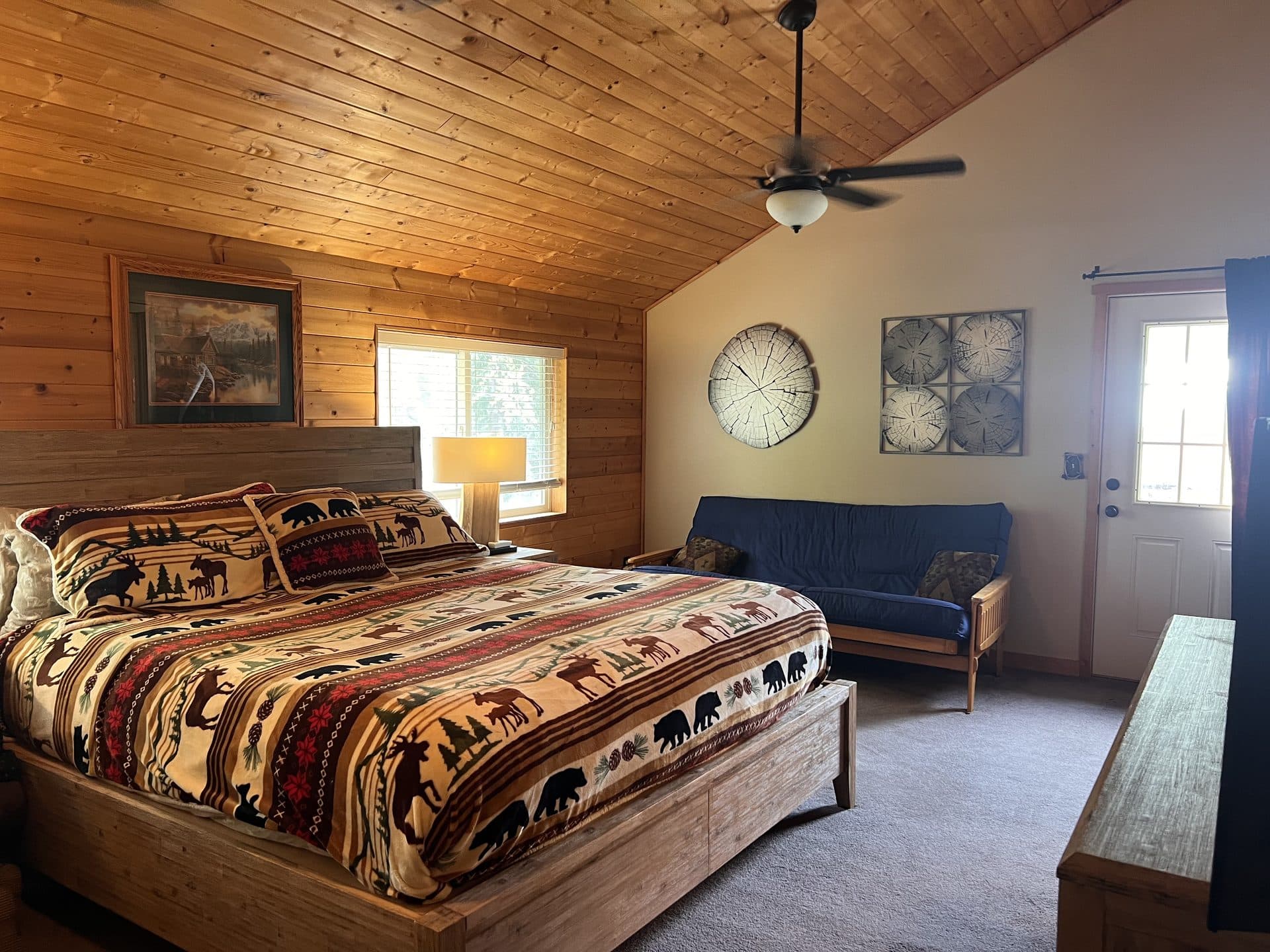 Lodge master bedroom with king bed and vaulted pine ceiling