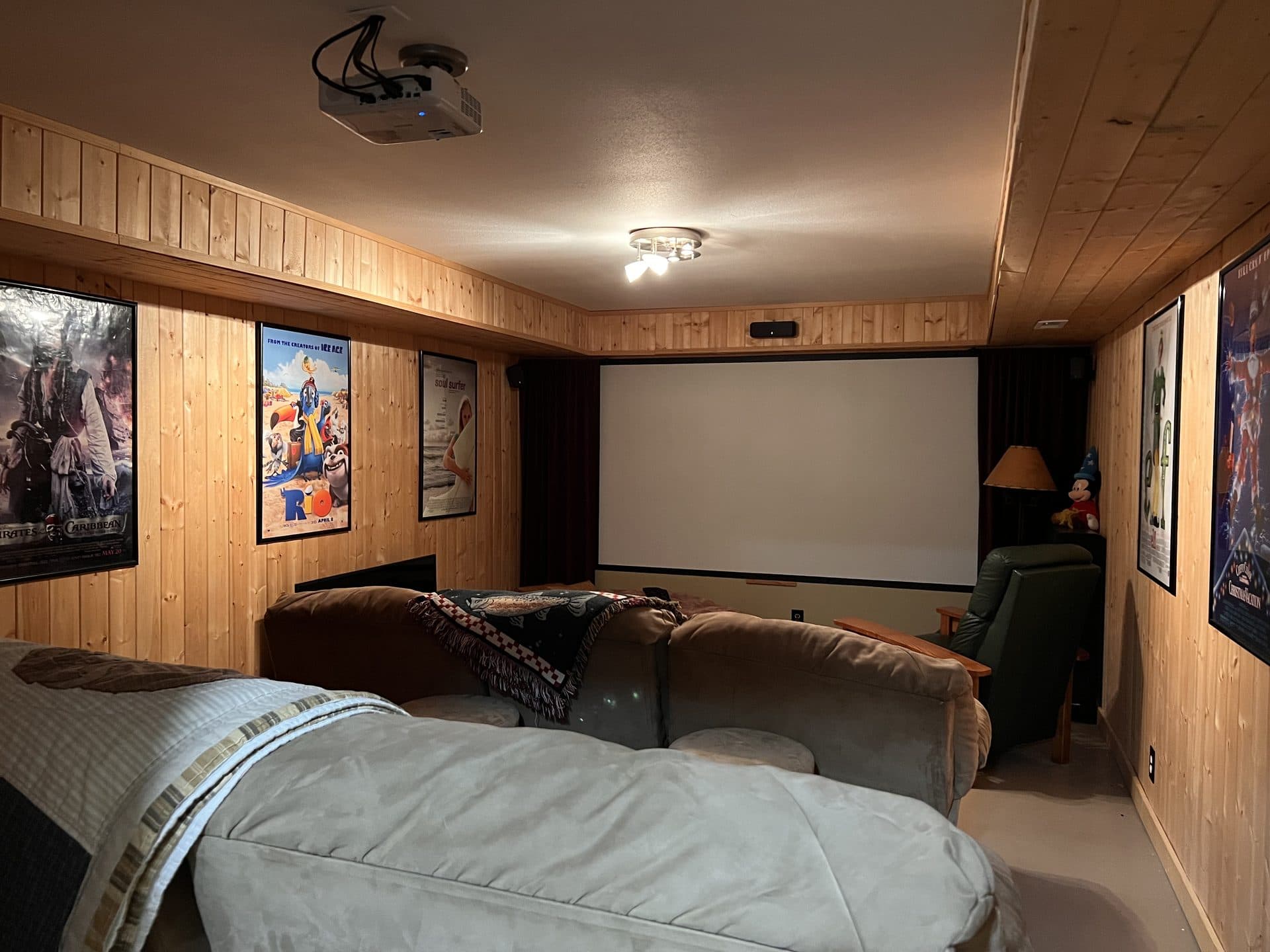Lodge movie theater room with projector screen and lounge seating